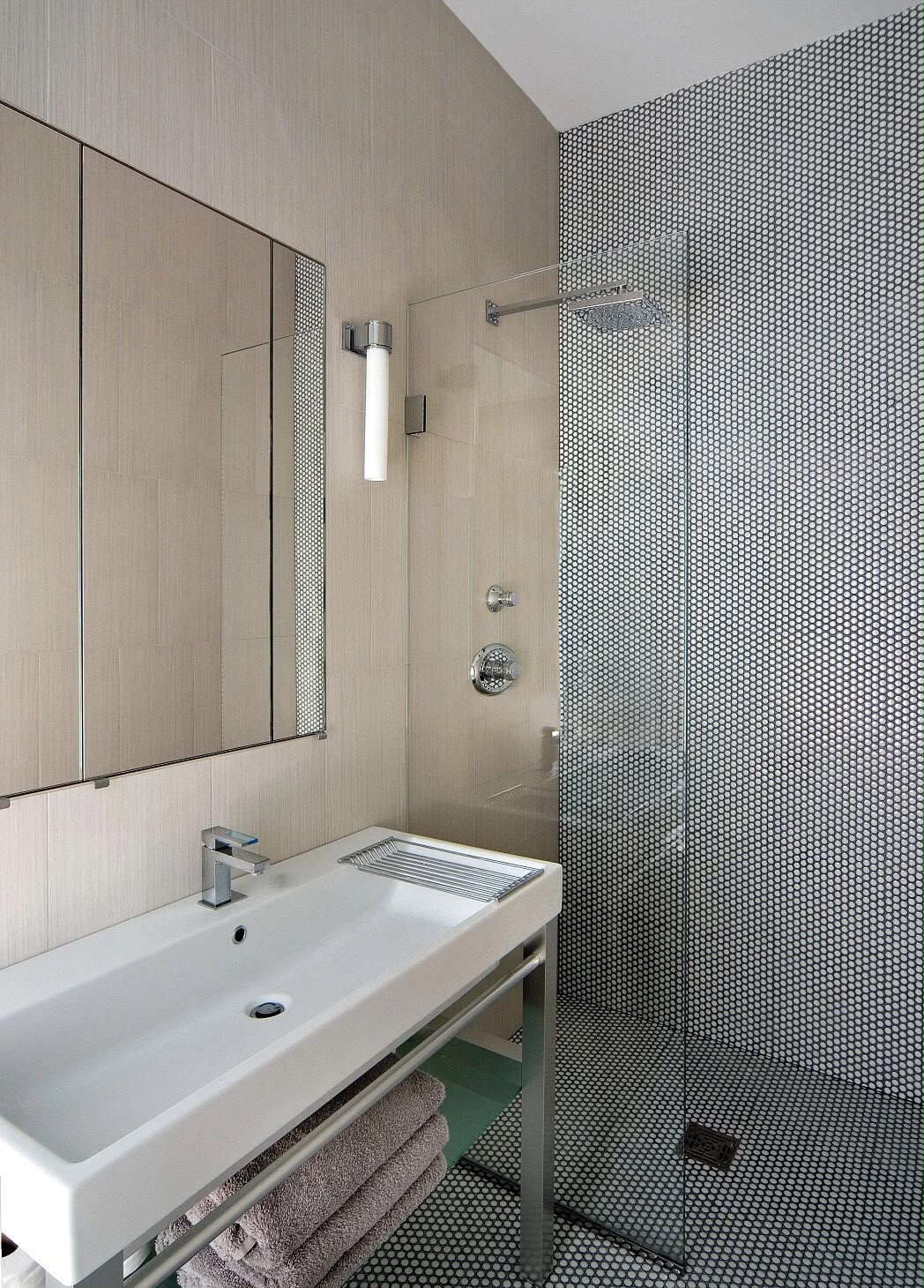 Modern bathroom with mosaic tile wall and glass shower partition